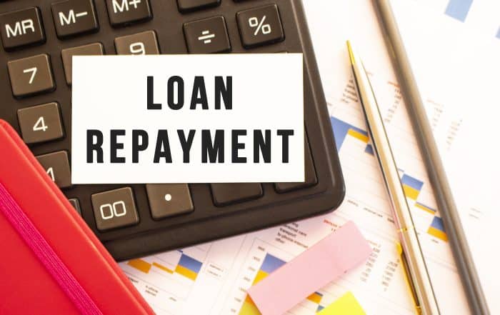 Text LOAN REPAYMENT on white card with metal pen, calculator and financial charts. What Happens if You Don’t Repay Your Personal Loan in Singapore?