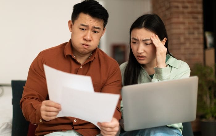 Stressed asian spouses checking financial papers upset mature husband and young wife looking at loan documents stressed asian couple checking their financial papers