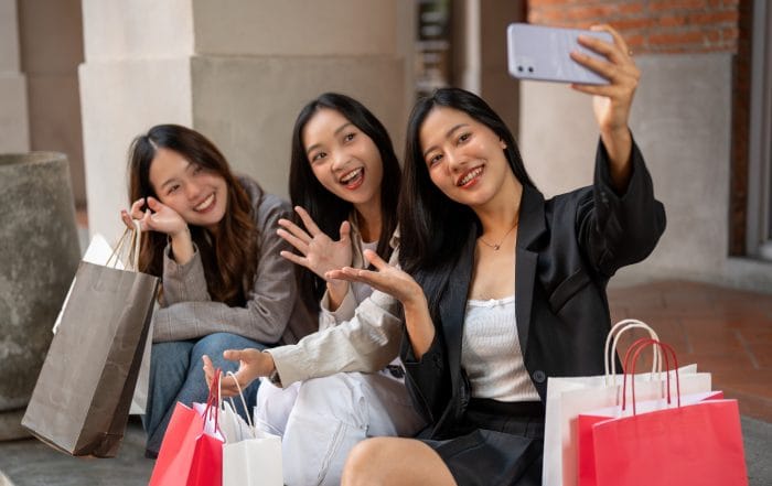Group of attractive Asian girls are taking selfies with a phone while sitting on the stairs together