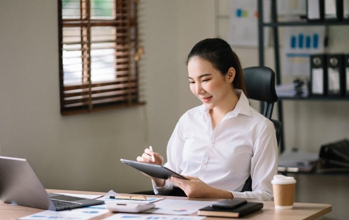 Confident Asian woman with a smile standing holding notepad and