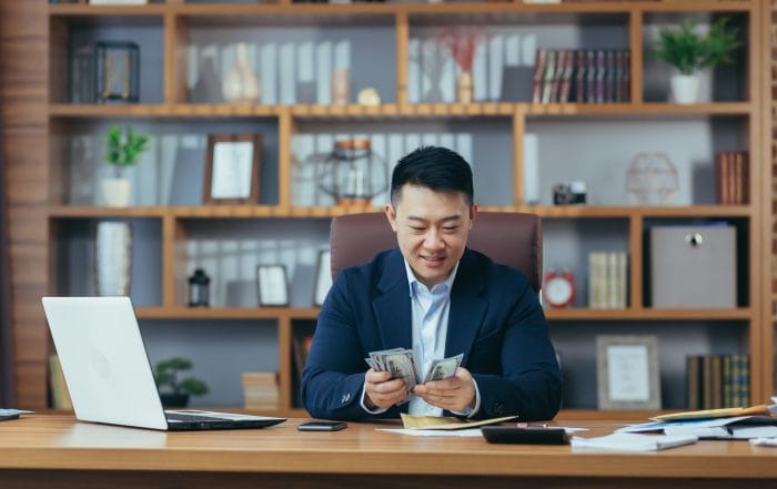 Satisfied young man asian office worker received money salary cash reward in an envelope counts